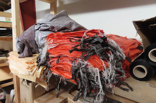 Indhold på reol af diverse tøj, handsker, presenning mv.