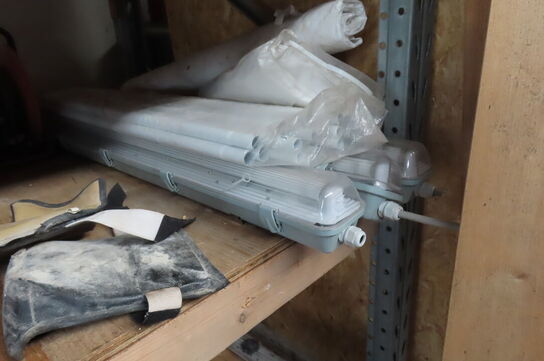 Indhold på reol af diverse lamper, varmeblæser, lysstofsrør mv.