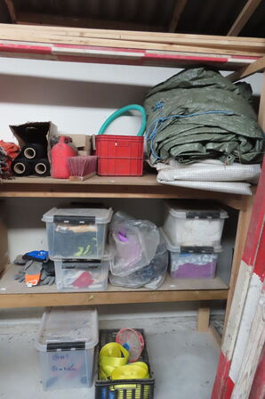 Indhold på reol af diverse tøj, handsker, presenning mv.