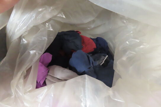 Indhold på reol af diverse tøj, handsker, presenning mv.