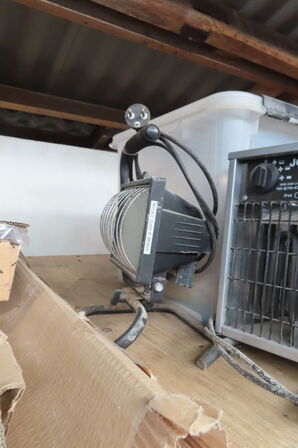 Indhold på reol af diverse lamper, varmeblæser, lysstofsrør mv.