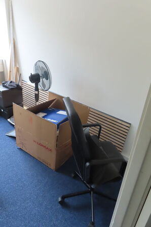 Indhold i rum af diverse papkasser, akkustikpaneler, kontorstol mv.