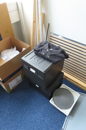 Indhold i rum af diverse papkasser, akkustikpaneler, kontorstol mv.