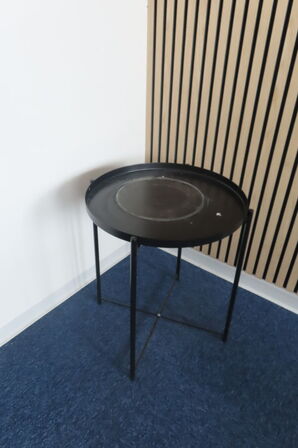 Indhold i hjørne af reoler, stativer samt planter i rummet