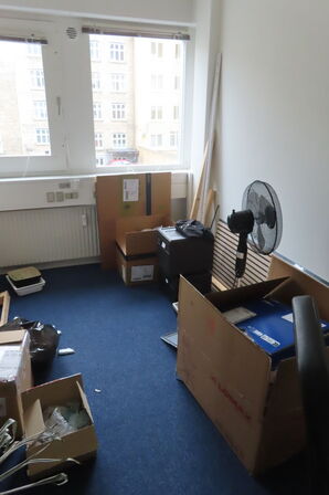 Indhold i rum af diverse papkasser, akkustikpaneler, kontorstol mv.