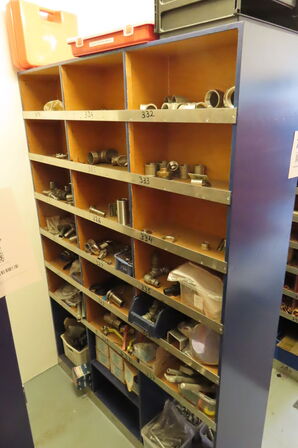 Reol med indhold af diverse beslag, fittings mv. 