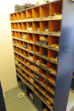 Reol med indhold af diverse beslag, fittings mv. 