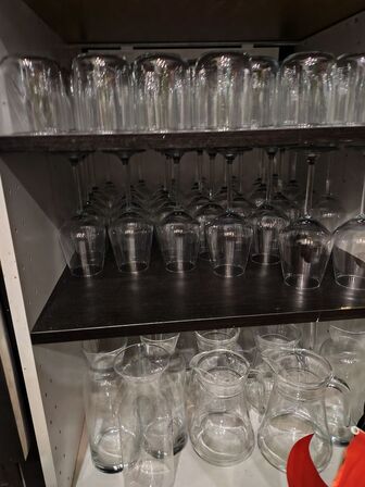 Glas, kander, vinkølere bag baren.