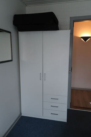 Rum med indhold bl.a. seng, div. Skabe, maleri, vægure m.m.