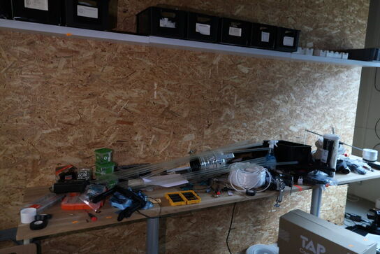 Arbejdsbord med div. Værktøj og varelager samt hylde med indhold