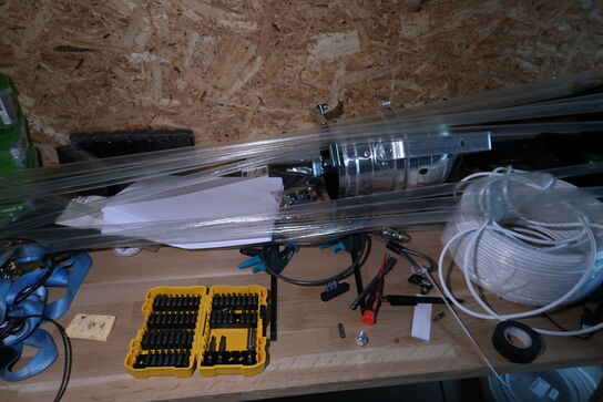 Arbejdsbord med div. Værktøj og varelager samt hylde med indhold