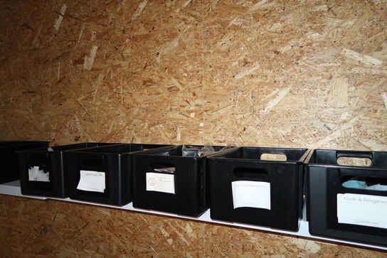 Arbejdsbord med div. Værktøj og varelager samt hylde med indhold