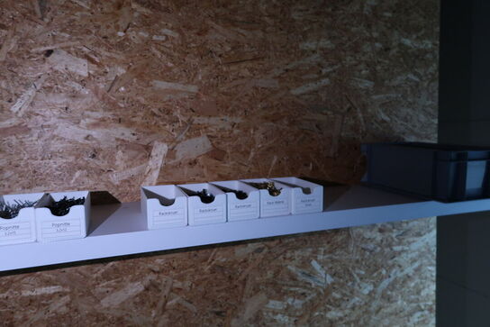 Arbejdsbord med div. Værktøj og varelager samt hylde med indhold